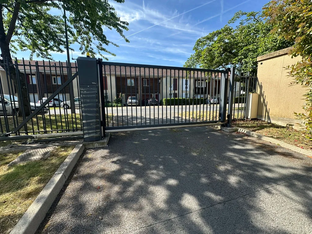 Portail coulissant barreaudé motorisé à l'entrée d'une résidence