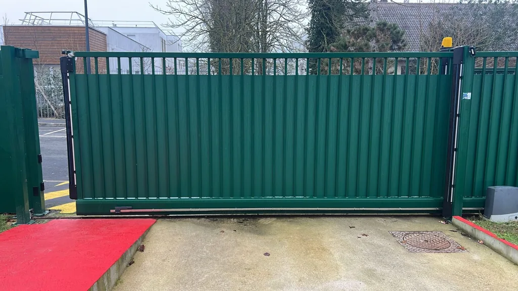Portail coulissant motorisé avec feu clignotant à l'entrée d'un site d'entreprise