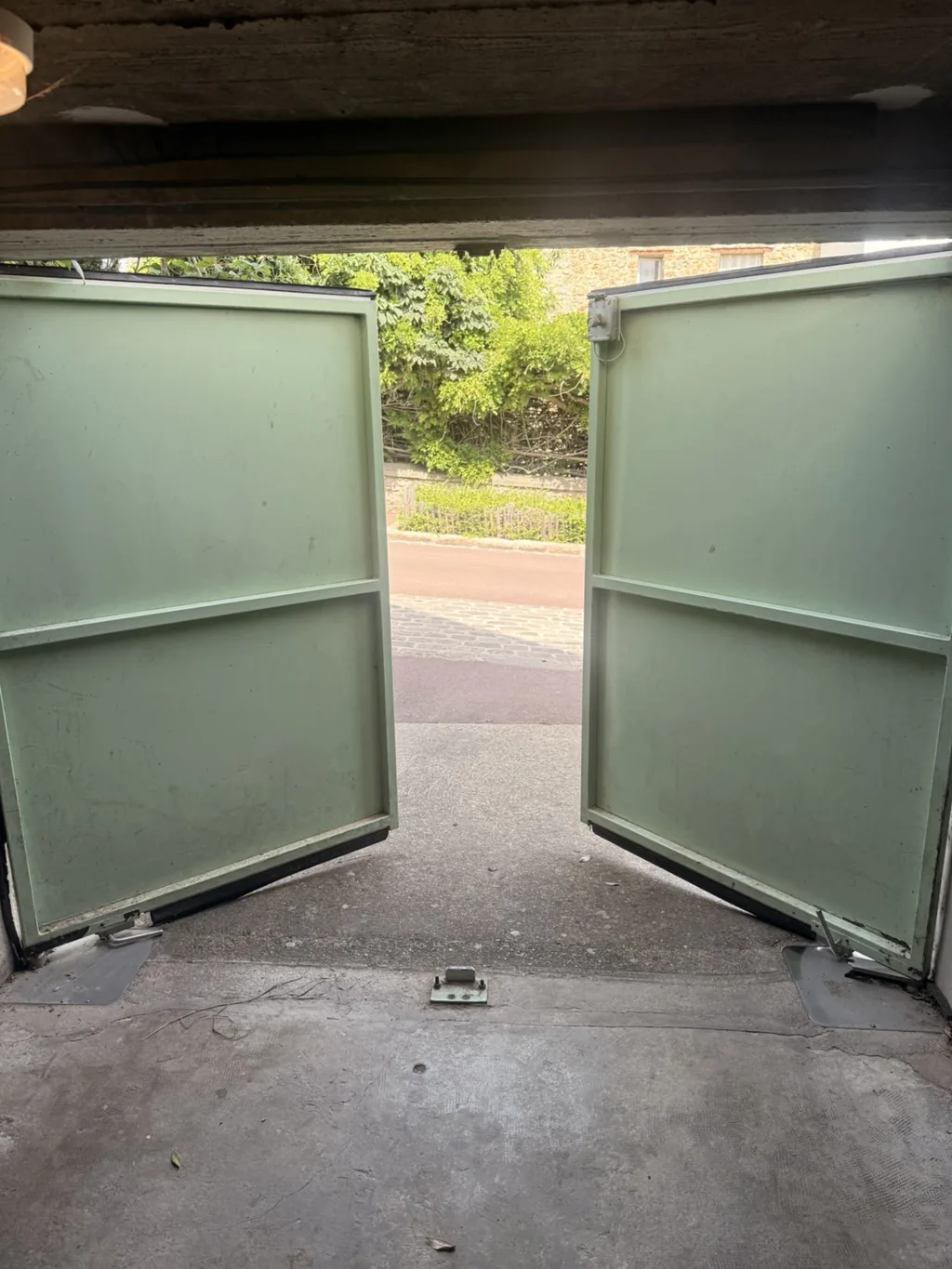 Porte de garage battante à deux vantaux vue depuis l'intérieur du garage